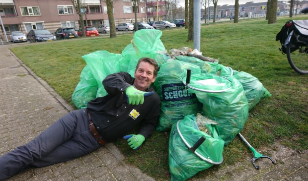 <p>Voldaan ligt André Steensma bij enkele van de zakken opgeraapt zwerfafval in Toolenburg: 'Onbegrijpelijk dat er zoveel op straat wordt gegooid.' </p>