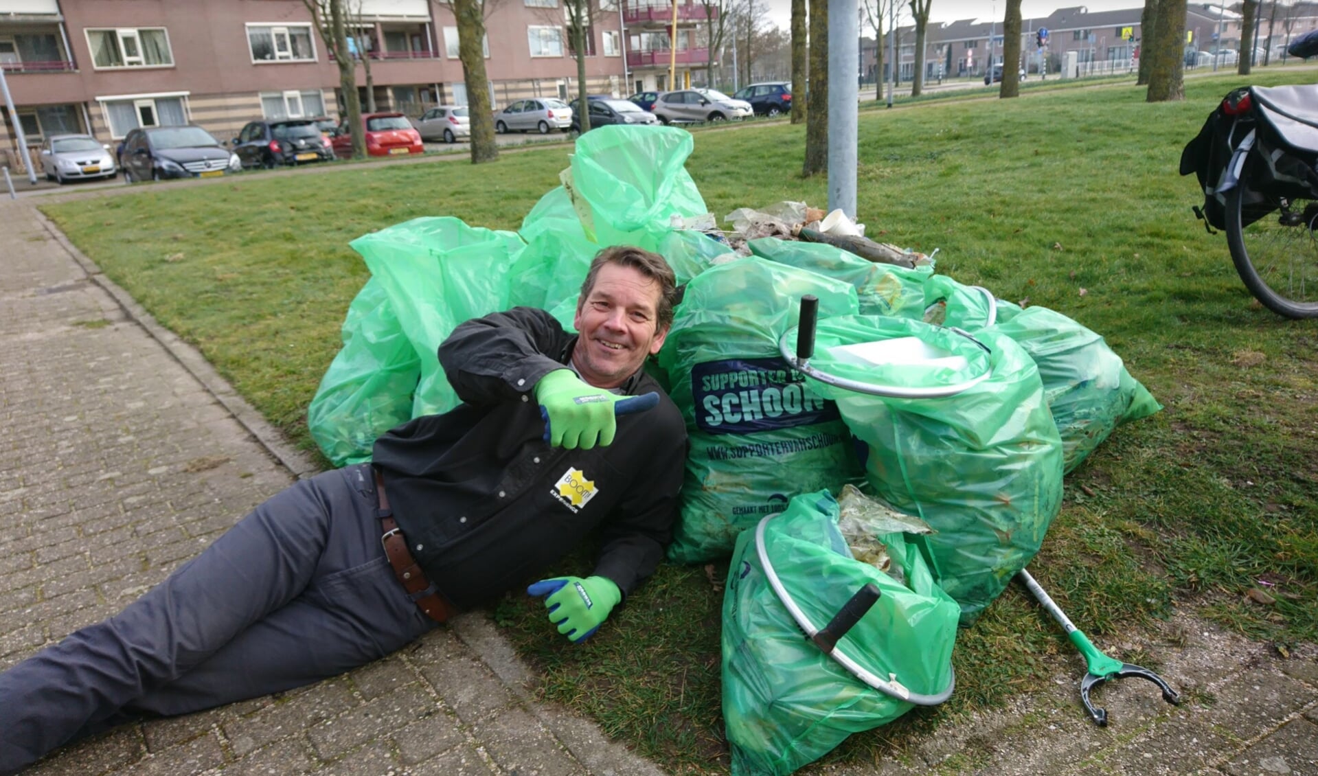 Voldaan ligt André Steensma bij enkele van de zakken opgeraapt zwerfafval in Toolenburg: 'Onbegrijpelijk dat er zoveel op straat wordt gegooid.'  