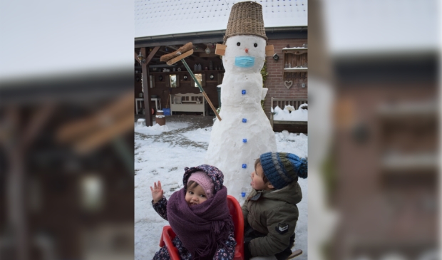 Ezra en Salomé hebben met opa een sneeuwpop gemaakt. Alles Corona-proof!