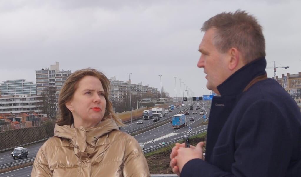 Minister Cora van Nieuwenhuizen op de uitkijktoren bij de A9 met op de achtergrond de te verbreden snelweg.
