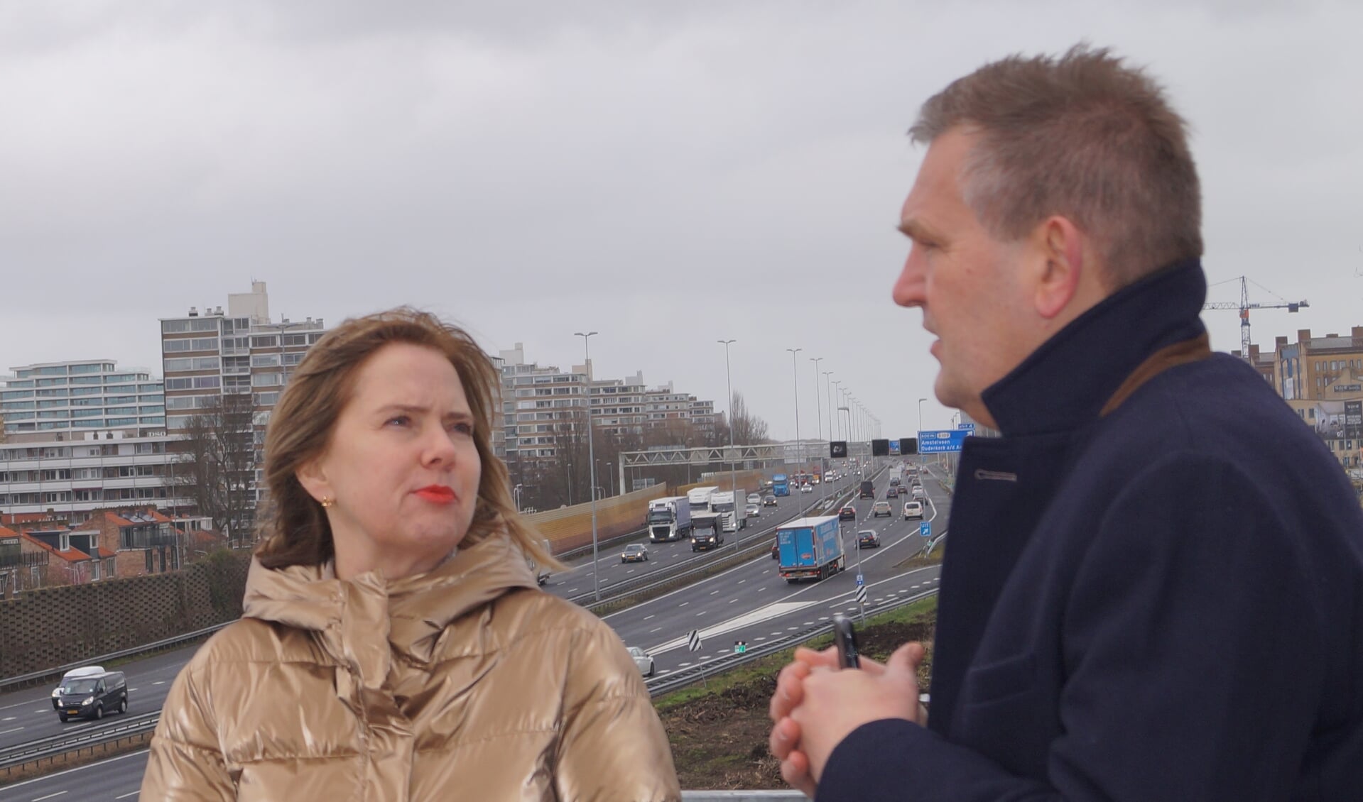 Minister Cora van Nieuwenhuizen op de uitkijktoren bij de A9 met op de achtergrond de te verbreden snelweg.