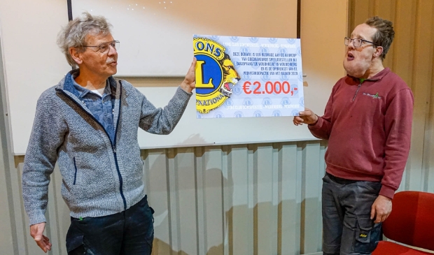 President Jo Beunders overhandigt de cheque aan Johan.