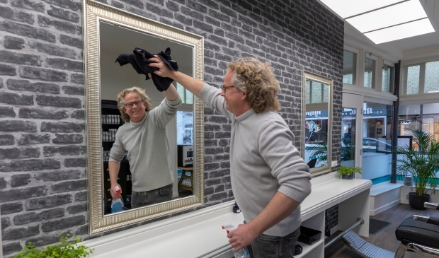 <p>Willem den Bleeker checkt of alles goed schoon is in de kapsalons alvorens hij woensdag weer open gaat</p>