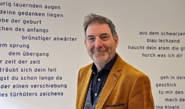 <p>Henk van Ommen in zijn directiekamer voor een gedicht van zijn hand: ,,Leven is ook risico nemen."</p>