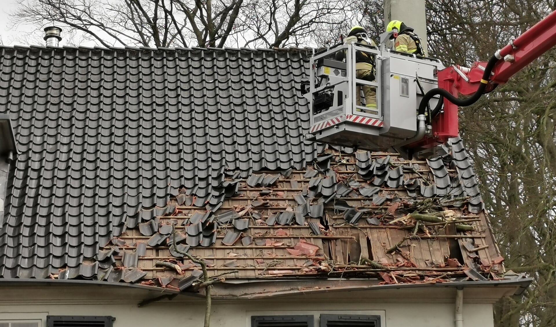 Een woning aan de Bovenweg in Bennekom raakte zwaar beschadigd toen een boom op het dak viel.