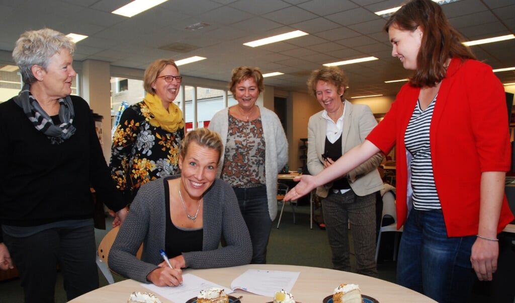 Wijkverpleegkundige Janina Hoogervorst ondertekent een overeenkomst in de bibliotheek in Renswoude.