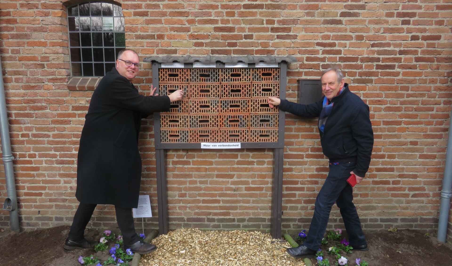 Pastoor Zemann (l) en dominee Kruijswijk Jansen hebben zojuist een briefje gepost.