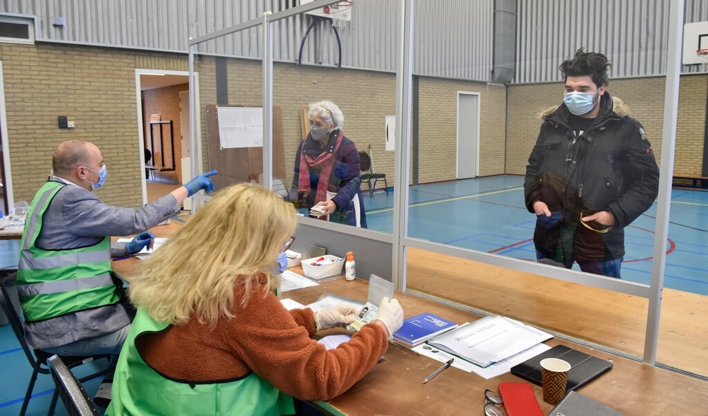 Ingrid Koomen-Beerman en Feddo van Ede bemensen de tafel van een van de twee stembureaus aan de Smitsweg.