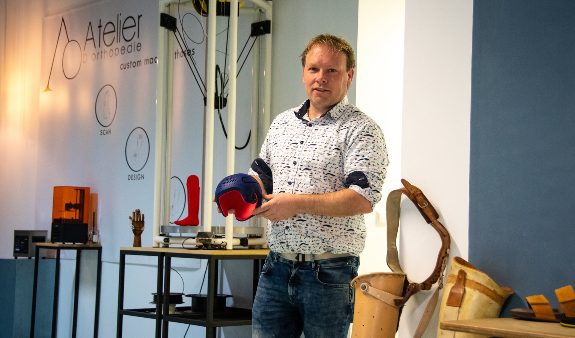 Jos Dölle houdt een redressiehelm vast, gemaakt met een 3D-printer.