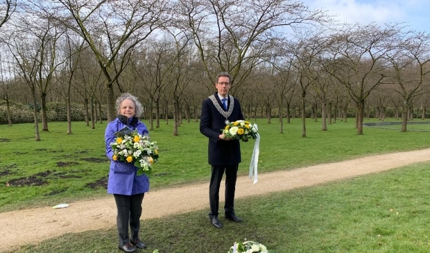 <p> Burgemeester Tjapko Poppens legt samen met Christa de Kemp, managing director DUJAT, bloemen bij het monument.</p>