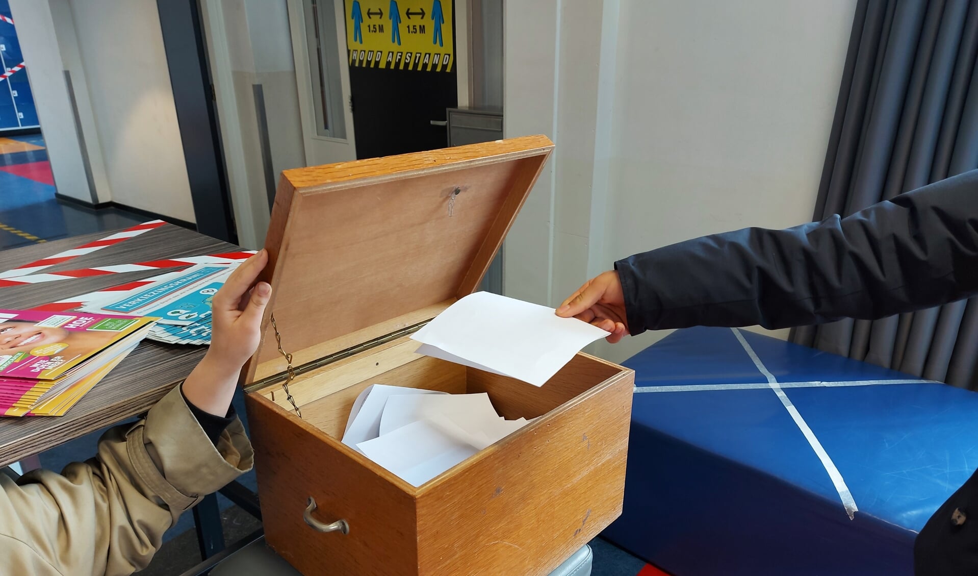 Een leerling doet zijn stembiljet in de stembus