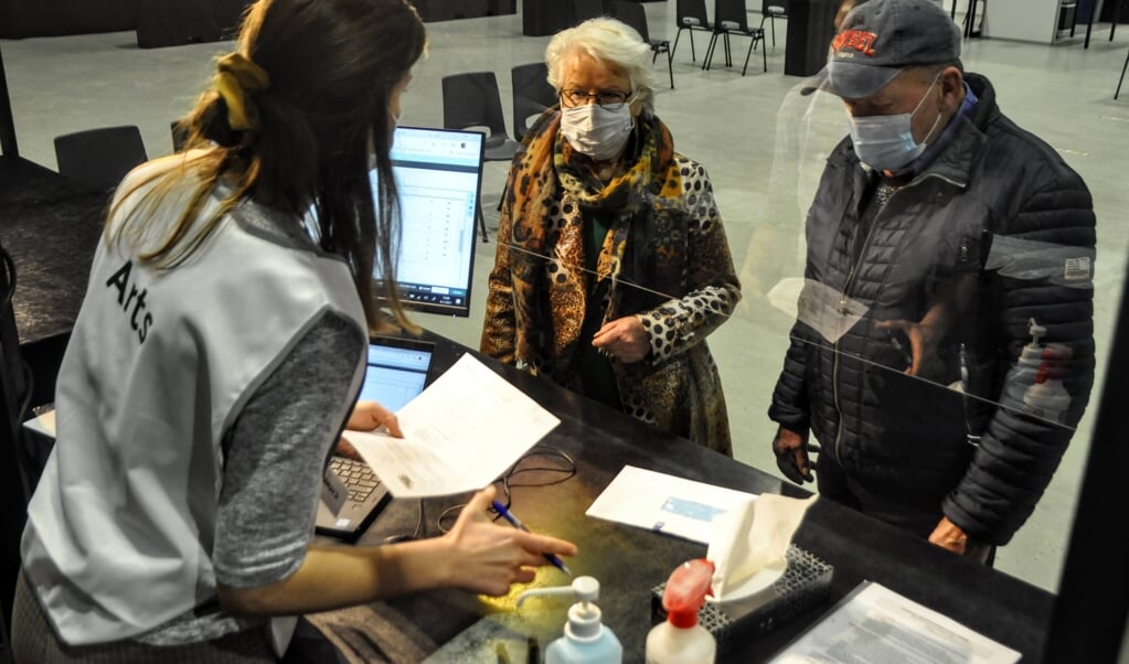 Een arts verwelkomt mensen in de vaccinatielocatie van de GGD in de Midden Nederland Hallen in Barneveld.