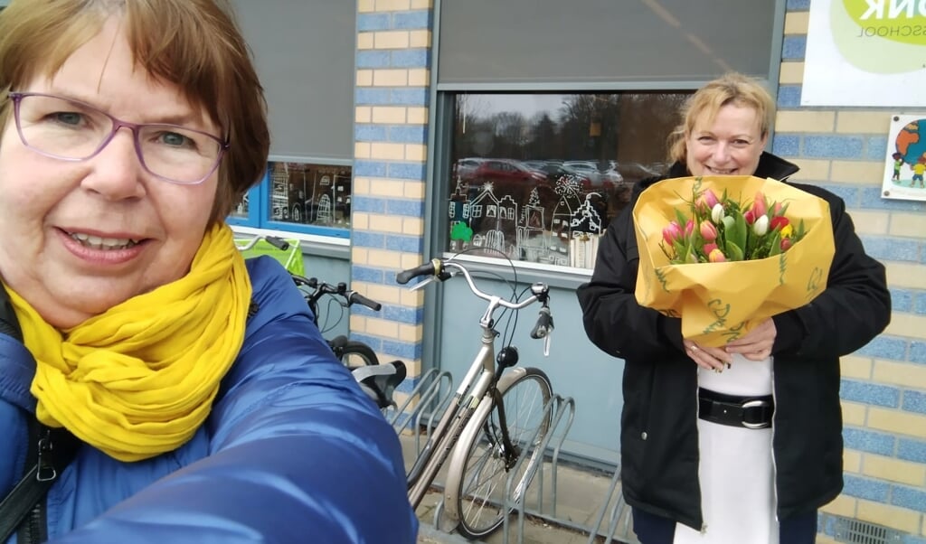 Wethouder Dekker reikte op Internationale Vrouwendag bloemen uit aan vrouwelijke basisschooldirecteuren, zoals hier aan Caroline Boumans van de Vonk