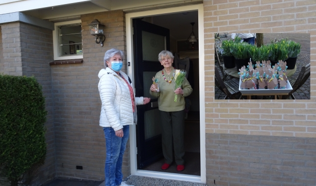 Aanbieden van een paasattentie aan een gast van de Zonnebloem
