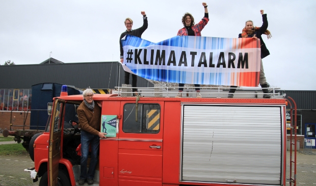 De initiatiefnemers van het Klimaatalarm Amersfoort: in de deur Hans van Dijk (Grootouders voor het Klimaat) en op de auto van links naar rechts Laurens van Hofslot (Dwars), Fieke Westland (Fridays fot Future) en Ronja Breuk (Extinction Rebellion).