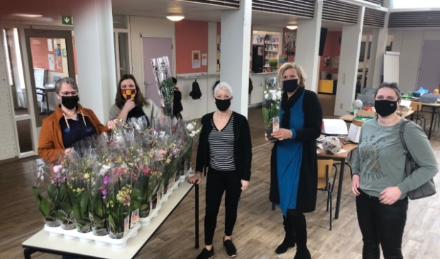 Leraren van basischool Klimop ontvangen de orchideeën.
