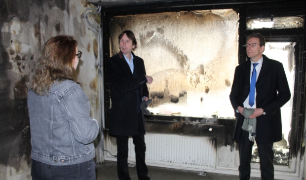 <p>Wethouder Herbert Raat en burgemeester Tjapko Poppens in de door de brand getroffen studentenwoning.</p>