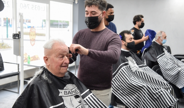 <p>Osman Simsek brengt het kapsel van Hans Festen weer in het gewenste model.</p>