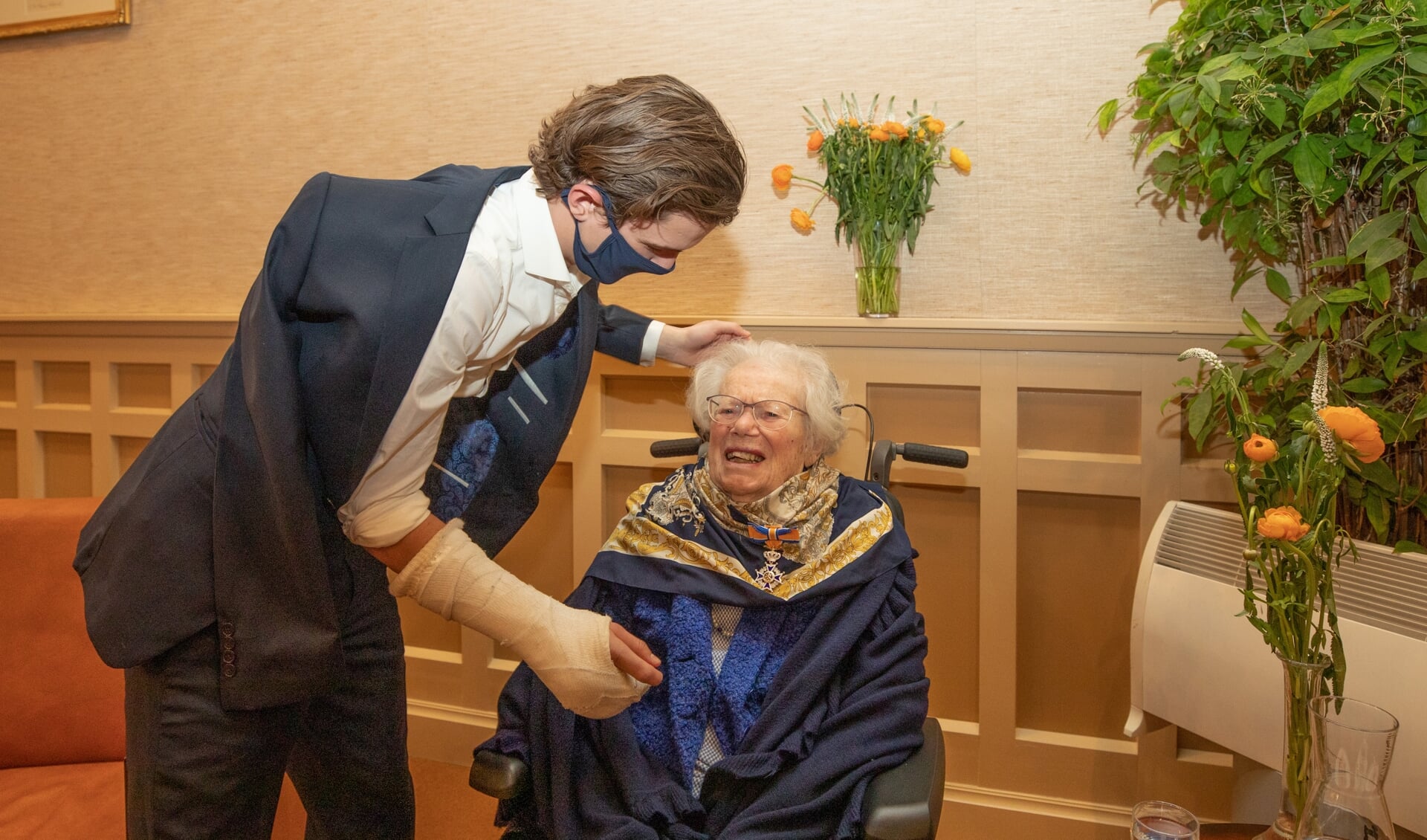 Kleinzoon Zoran overhandigt de koninklijke onderscheiding aan zijn oma. 
