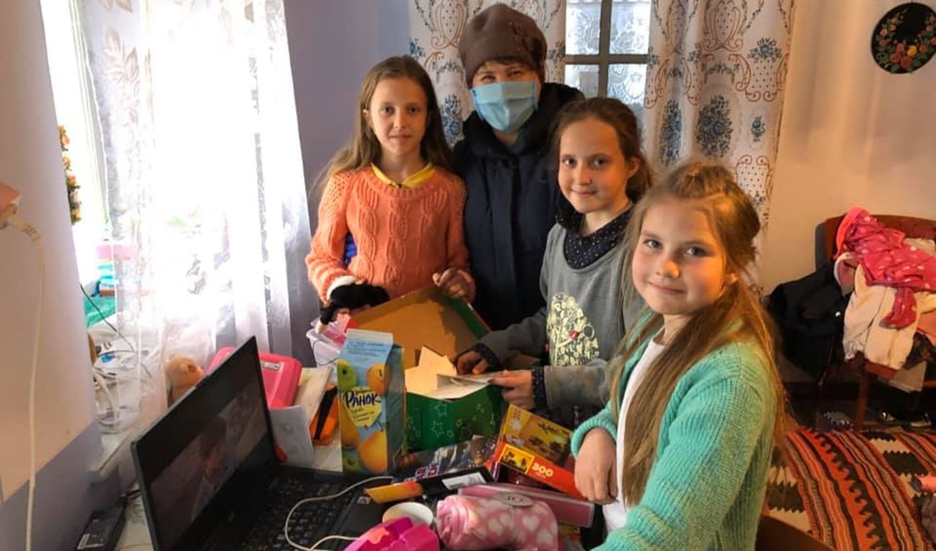 Ruslana, lokale partner van Kom over en help in Oekraïne bezoekt kinderen thuis met een zorgpakket. 