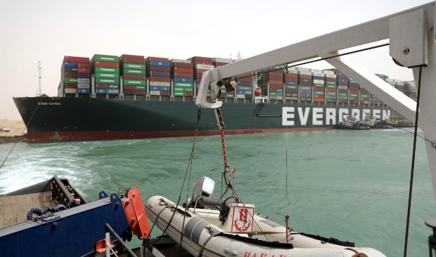 2021-04-01 00:00:00 epa09095681 A handout photo made available by the Suez Canal Authority, shows the Ever Given container ship in the Suez Canal, Egypt, 25 March 2021. the Ever Given, a large container ship ran aground in the Suez Canal on 23 March, blocking passage of other ships and causing a traffic jam for cargo vessels. The head of the Suez Canal Authority announced on 25 March that "the navigation through the Suez Canal is temporarily suspended" until the floatation of the Ever Given is completed. Its floatation is being carried out by 8 large tugboats that are towing and pushing the grounding vessel. EPA/SUEZ CANAL AUTHORITY/HO EDITORIAL USE ONLY NO SALES HANDOUT EDITORIAL USE ONLY/NO SALES