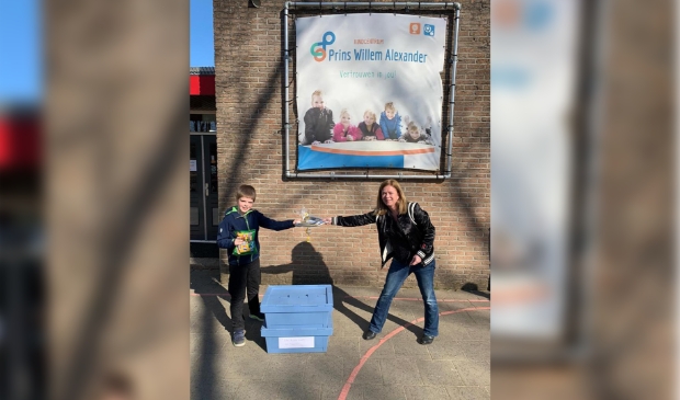 Astrid Herder van de Bibliotheek overhandigt de prijs aan Imo uit groep 7/8 van de Prins Willem-Alexanderschool