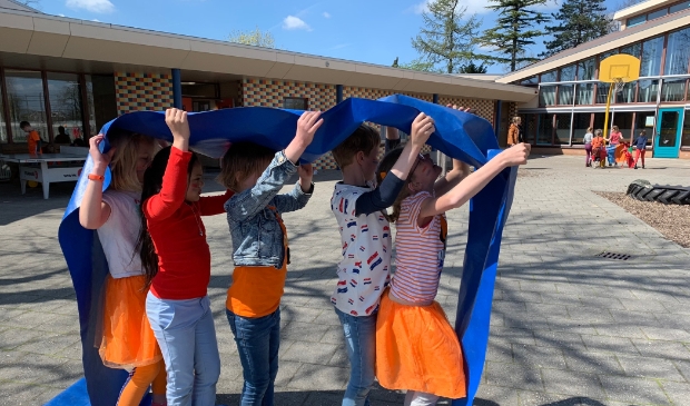 Leerlingen van de Koepelschool spelen spelletjes op het schoolplein