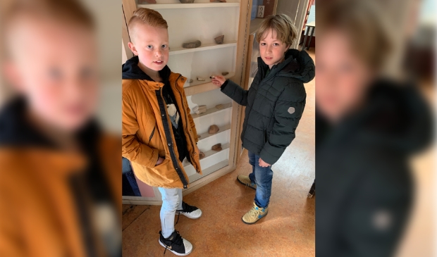 Tycho en Finn bij de vitrinekast in het museum.