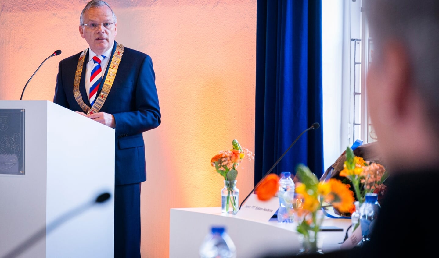 Burgemeester Jan Luteijn, spreekt een van de gedecoreerden toe.