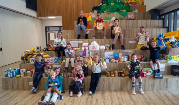 • Enkele leerlingen van kindcentrum Berkelwijk poseren trots tussen een deel van de opbrengst van hun sociale collecte.