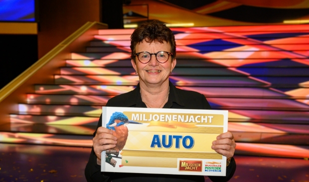 <p>Rina uit Putten toont de cheque voor de auto.</p>