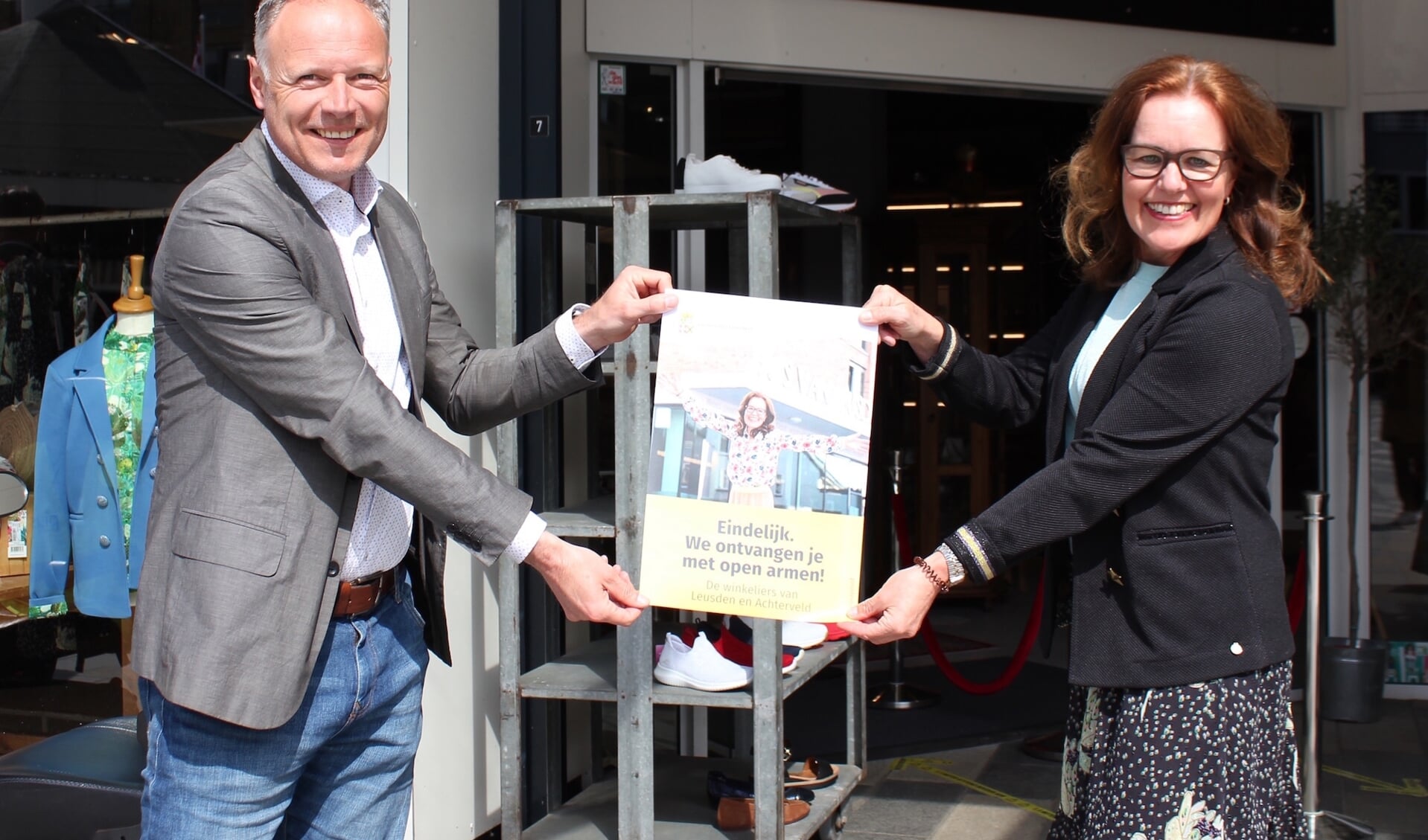 Wethouder Patric Kiel overhandigt de poster van Panterhuis aan Evelien Korlaar.