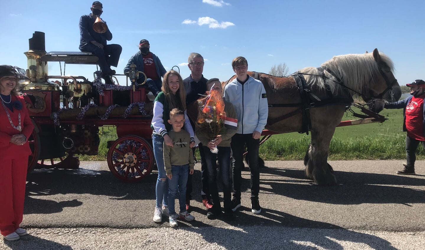 Wim van Duuren poseert met zijn kleinkinderen bij de stoomspuit van de brandweer