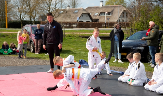 <p>Thijs van Huigenbos kijkt toe, evenals andere belangstellenden in en om de auto.</p>