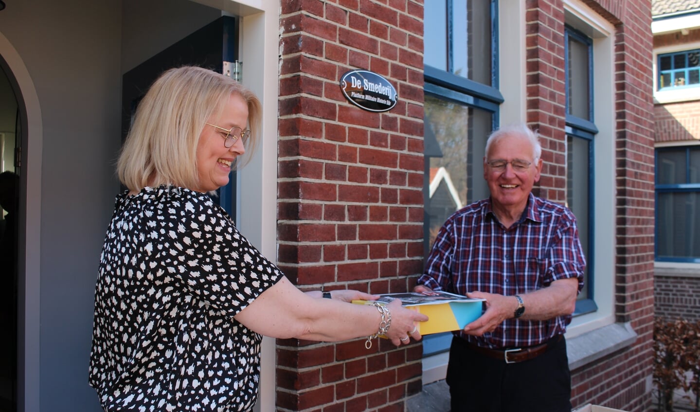 PMHE-veteranenbestuurslid Renske van Dijk overhandigt een Paasbrood aan Edese veteraan Wybo Boersma.