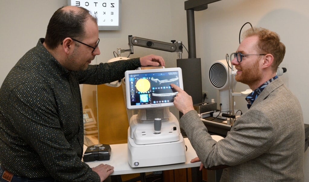 Opticien Aris van den Berg (links) en optometrist Christian de Lijster bij de nieuwe OCT-netvliesscan.