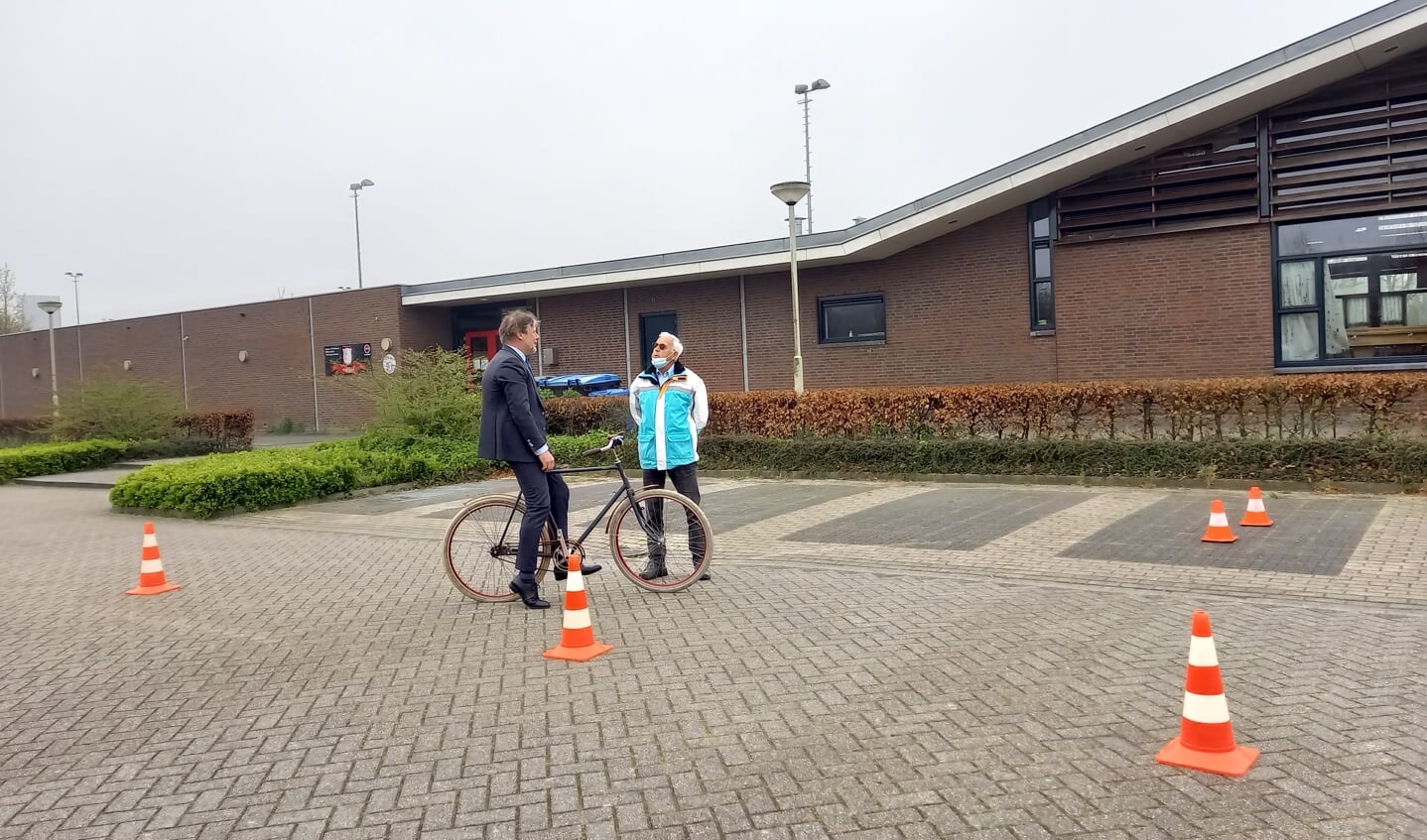 Werthouder Ro van Doesburg krijgt instructies van een vrijwilliger van VVN voordat hij het fietsparcours aflegt. 