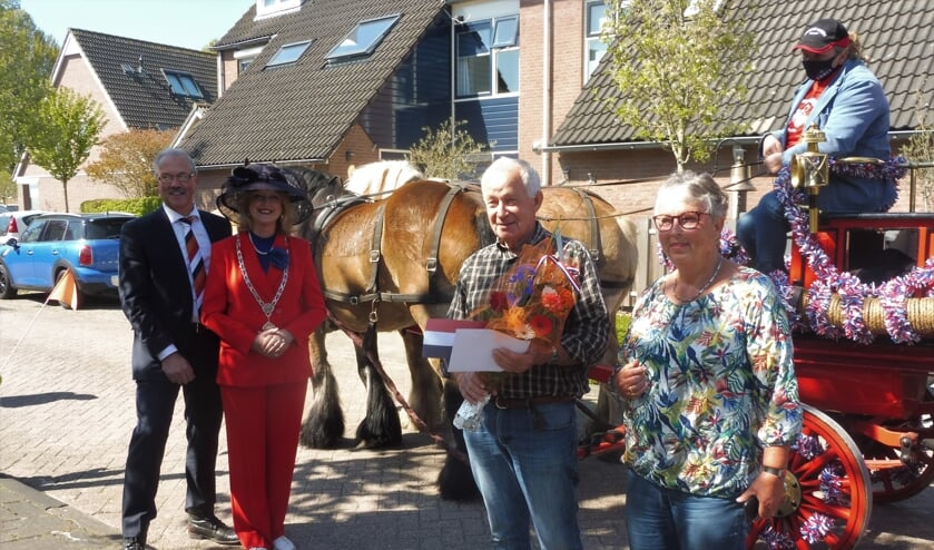 Wim Huurman poseert met zijn vrouw bij de brandweerspuit, links burgemeester Melissant