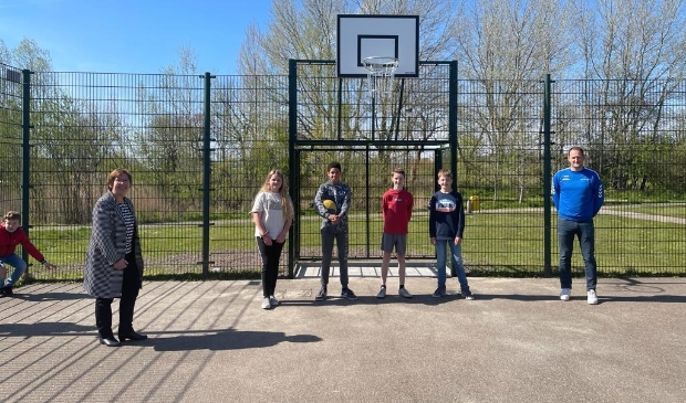 <p>Wethouder Dekker (links), Jasper Oele (rechts) en tussen hen in Dominique, Jayden, Wieger en Seth, bij de opening van het basketbalveld in Odijk</p>
