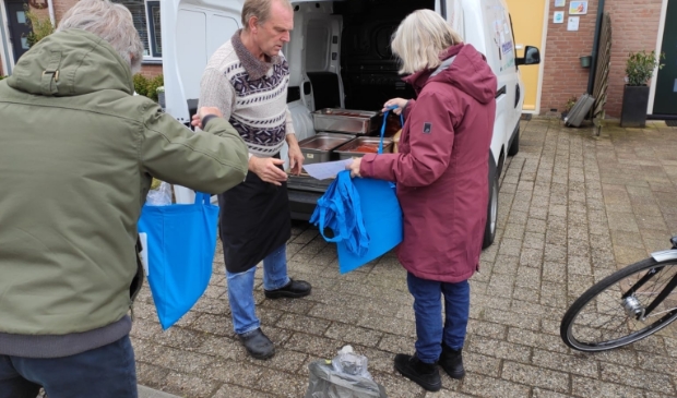 Traiteur Nol verdeelt de soepen onder de vrijwilligers
