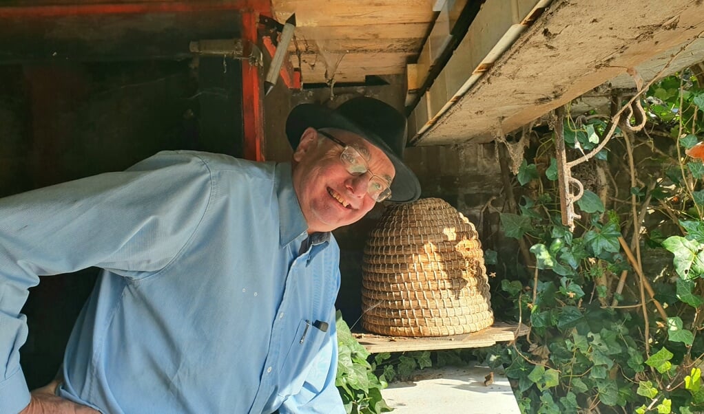 Henk Vernooij bij een bijenkorf, waar hij spontaan les geeft over bijen.