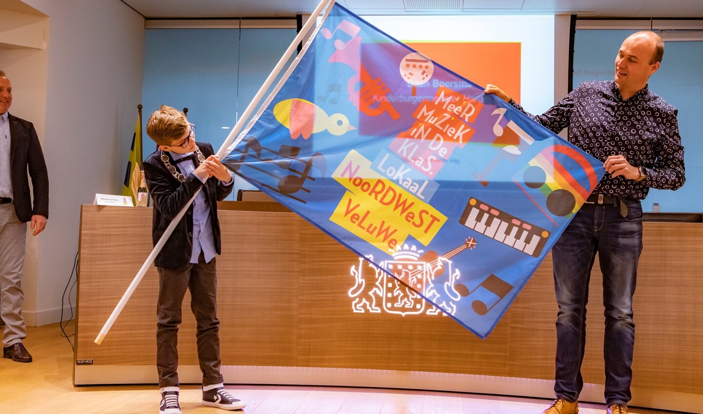Directeur Sander van Zomeren toont de winnende vlag van de Gabriëlschool met de kinderburgemeester van Harderwijk.