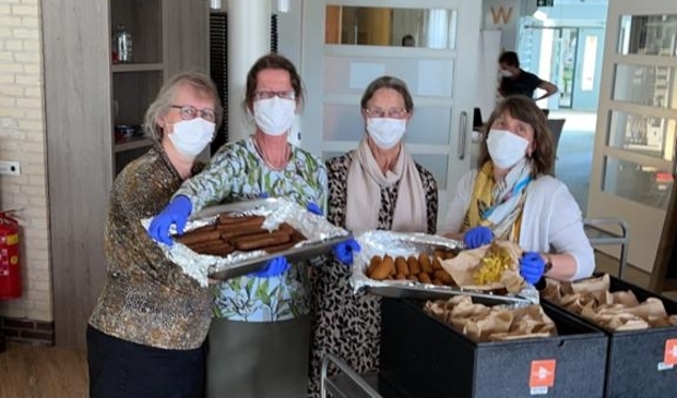 <p>Medewerkers van Zorgcentrum Elim tonen de bijzondere warme maaltijd die de bewoners woensdagmiddag kregen. </p>