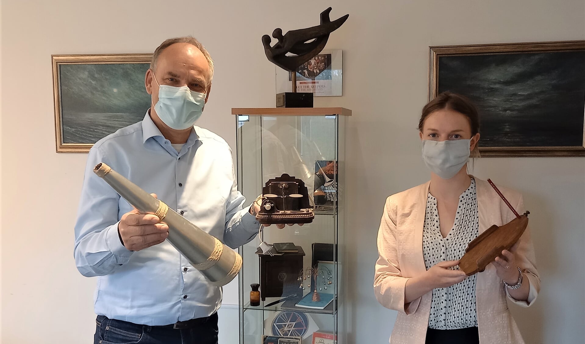 Wim Kramer en collega Lotje Vermeulen in hun kantoor met enkele artefacten.