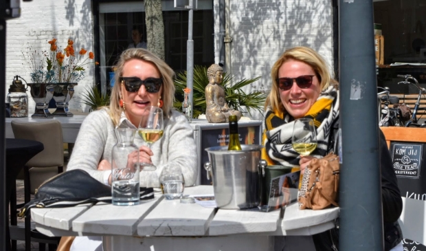 <p>Twee dames genieten op een terrasje op de Binnenweg.</p>