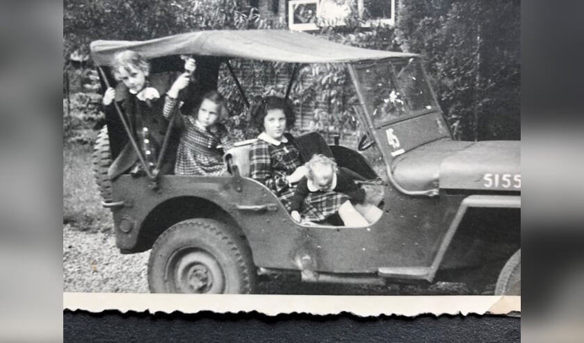 De 11 jarige Loes Kuiper uit Doorn (voorstoel) met haar drie zussen in de leger jeep.