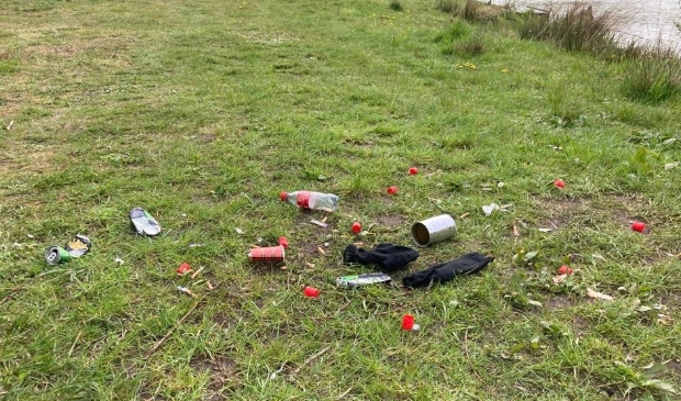 Afval van sportvissers aan waterkant achter ijsbaan in Odijk
