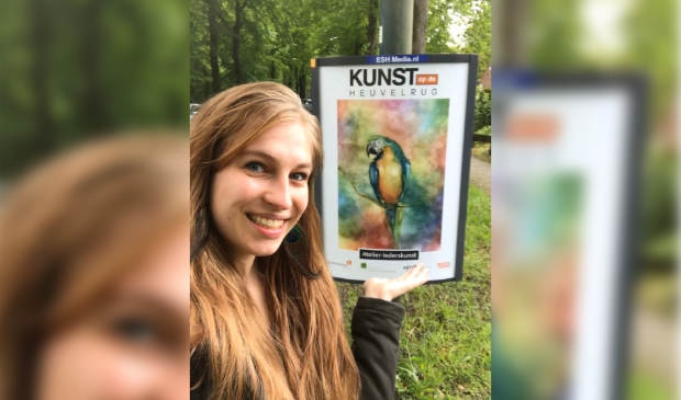 De cultuurcoach bij een van de borden