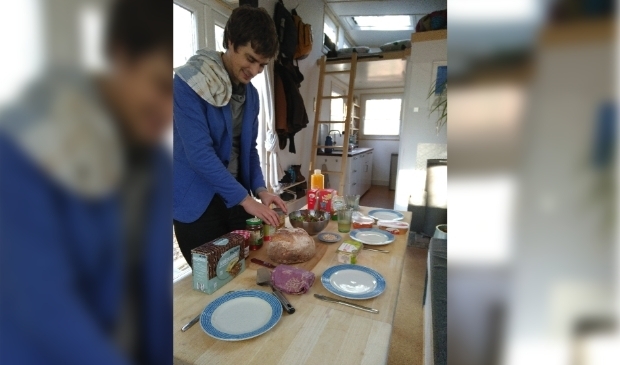 Joachim zet de lunch klaar in het tiny house.