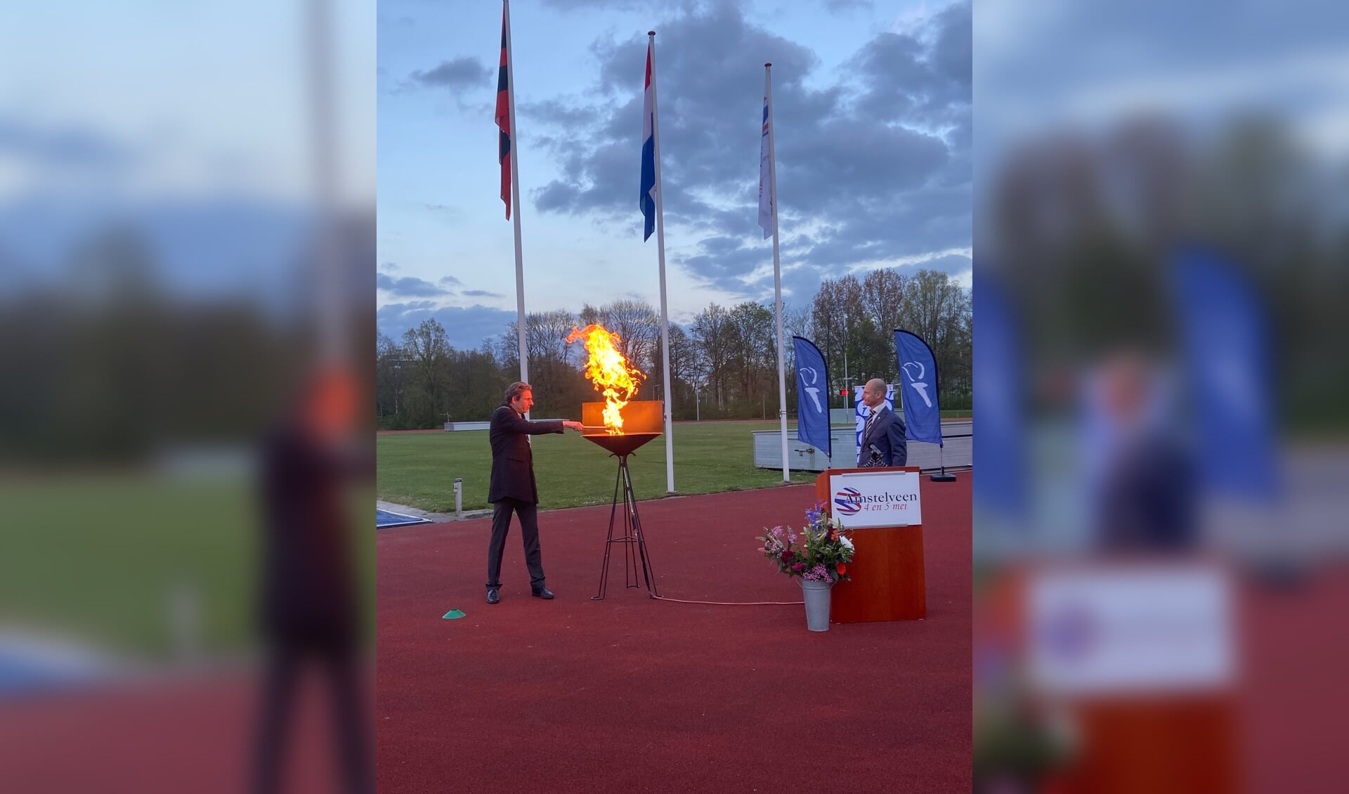 Burgemeester Tjapko Poppens ontsteekt het bevrijdingsvuur onder toeziend oog van Wilbert Hartman, voorzitter van Amstelveen Oranje.